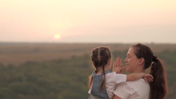 Famiglia felice cammina all'aperto. Il bambino batte la mamma sul palmo della mano, ciao. Mamma gioca con la sua figlioletta tra le braccia. Mamma e il suo amato bambino si divertono insieme. Felice concetto di famiglia. Lavoro di squadra. Cammina all'aperto — Video Stock