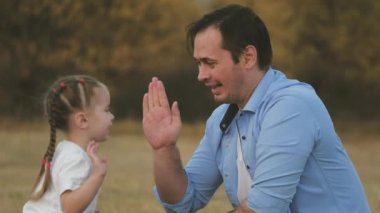 Babam küçük kızıyla el ele oynuyor. Baba ve sevgili çocuk birlikte eğlenin. Mutlu aile kavramı. Takım çalışması. Kid ve adam parkta çok eğleniyorlar. Doğa yürüyüşleri.