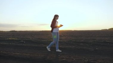 Çiftçi ekmeden önce toprağın kalitesini kontrol eder. Tarlada tableti olan kadın çiftçi. İş kadını tarladaki tohum ekme işlerini kontrol ediyor. Bir kadın tarım uzmanı ekilen tahılın kalitesini kontrol eder..