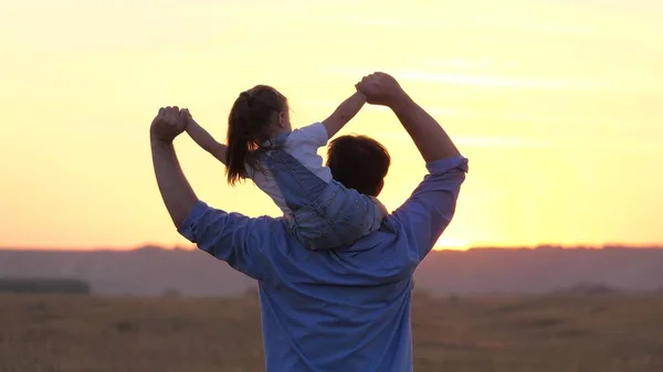 Bambino e papà sognano di diventare un pilota. bambino siede sul collo padri agitando le braccia insieme, vola come un aereo. Un padre di famiglia felice con un bambino sulle spalle. Padre spensierato con sua figlia — Foto Stock