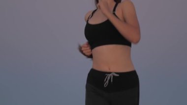 Antrenman koşusu. Koşucu kız sahada temiz hava soluyor. Özgür genç bir kadın gün batımında yaz parkında koşar. Sağlıklı, güzel bir kız spor yapıyor, kırsalda güneş altında koşuyor..
