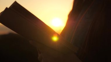 Bir insan güneşte kitap okur. Adam dışarıda İncil okuyor. Bir adam İncil 'i elinde tutuyor ve dağın tepesinde gündoğumunda Tanrı' nın kelamını okuyor. O sayfalarda, gerçeğin peşindedirler..