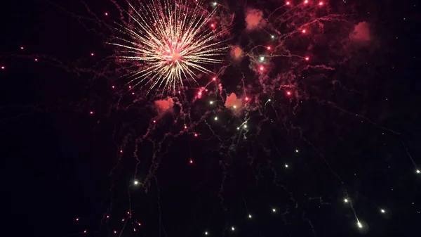 Schijnend vuurwerk met bokeh lichten aan de nachtelijke hemel. gloeiende vuurwerk show. Oudejaarsavond vuurwerk vieren. veelkleurig vuurwerk in de nachtelijke hemel. mooie gekleurde nacht explosies in het zwart — Stockfoto