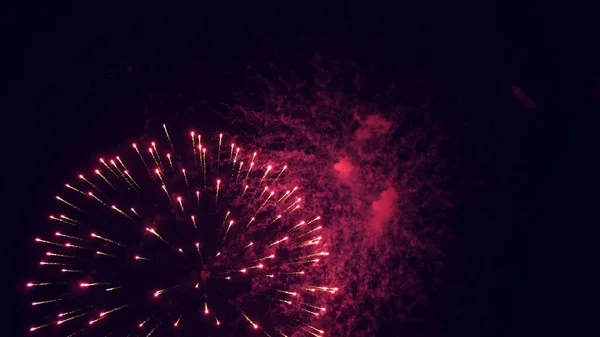 Schijnend vuurwerk met bokeh lichten aan de nachtelijke hemel. gloeiende vuurwerk show. Oudejaarsavond vuurwerk vieren. veelkleurig vuurwerk in de nachtelijke hemel. mooie gekleurde nacht explosies in het zwart — Stockfoto