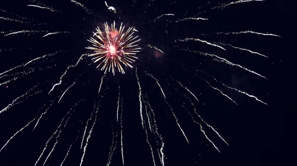 Leuchtendes Feuerwerk mit Bokeh-Lichtern am Nachthimmel. Glühendes Feuerwerk. Silvesterfeuerwerk. Ein buntes Feuerwerk am Nachthimmel. schöne farbige nächtliche Explosionen in schwarz — Stockfoto
