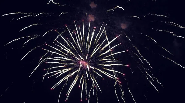 Schijnend vuurwerk met bokeh lichten aan de nachtelijke hemel. gloeiende vuurwerk show. Oudejaarsavond vuurwerk vieren. veelkleurig vuurwerk in de nachtelijke hemel. mooie gekleurde nacht explosies in het zwart — Stockfoto