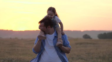 Çocuk babasının boynuna oturur ve sevgili babasına sarılır. Şirin bebek babamla oynuyor. Omuzlarında bebek olan mutlu bir aile babası. Parkta kızıyla birlikte tasasız bir ebeveyn. Mutlu aile