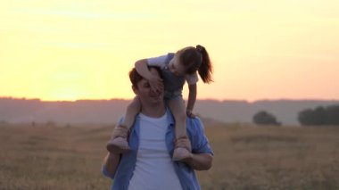 Çocuk babasının boynuna oturur ve sevgili babasına sarılır. Şirin bir kız babasıyla oynuyor. Omuzlarında bebek olan mutlu bir aile babası. Parkta kızıyla birlikte tasasız bir ebeveyn. Mutlu aile