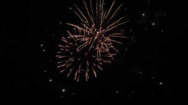 Ein buntes Feuerwerk am Nachthimmel. Leuchtendes Feuerwerk mit Bokeh-Lichtern am Nachthimmel. Glühendes Feuerwerk. Silvesterfeuerwerk. Schöne farbige nächtliche Explosionen am schwarzen Himmel — Stockfoto