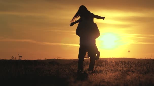 恋人の男性と女性のフィールド内の太陽の明るい線で踊る。ビーチの夕日で気楽に踊る家族。自由人だ。幸せな男ダンスとスピニングとともに彼のガールフレンドで夜に夏の公園. — ストック動画