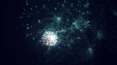 Siyah gökyüzünde renkli gece patlamaları. Gece gökyüzünde çok renkli güzel havai fişekler. Yeni yıl arifesi havai fişek kutlaması. Gece gökyüzünde havai fişek gibi parlayan ışıklar. Parlayan havai fişek gösterisi.