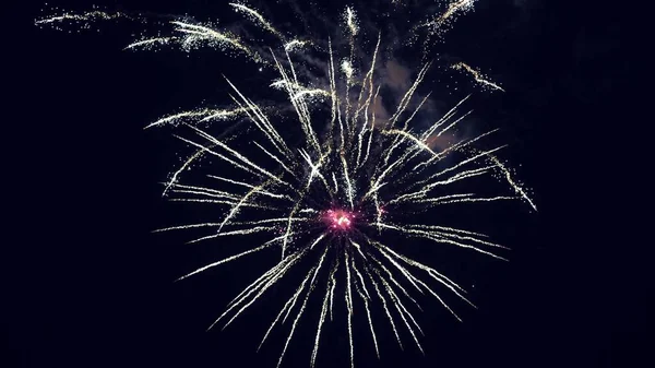 Farbige nächtliche Explosionen am schwarzen Himmel. schönes mehrfarbiges Feuerwerk am Nachthimmel. Silvesterfeuerwerk. leuchtendes Feuerwerk mit Bokeh-Lichtern am Nachthimmel. Glühendes Feuerwerk. — Stockfoto