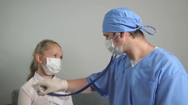 Dokter kinderarts onderzoekt kind. Kinderarts brengt stethoscoop op kinderen terug, luistert naar het hart en de longen van tienermeisje. De dokter luistert naar de hartslag van de baby. Kind in een ziekenhuiskamer. — Stockvideo