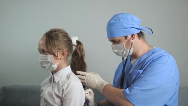 Kinderarts brengt stethoscoop op kinderen terug, luistert naar het hart en de longen van tienermeisje. Dokter kinderarts onderzoekt kind. De dokter luistert naar de hartslag van de baby. Kind in een ziekenhuiskamer. — Stockvideo