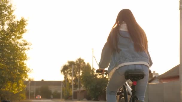 Girl Kid Riding Bike in Summer in City. Krásná dospívající dívka jezdí na kole v parku na ulici, slunečný den. Holka se kutálí, pohled zezadu. Puberťák jezdí na kole v parku. Zdravotní a sportovní koncept — Stock video