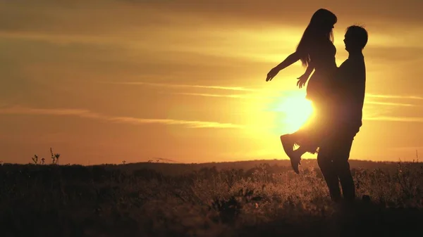 Älskar man och kvinna dansar i ljusa solstrålar på fältet. sorglös familjedans vid solnedgången på stranden. Fria människor. Glad kille dansar och snurrar med sin flickvän på kvällen i sommar Park. — Stockfoto