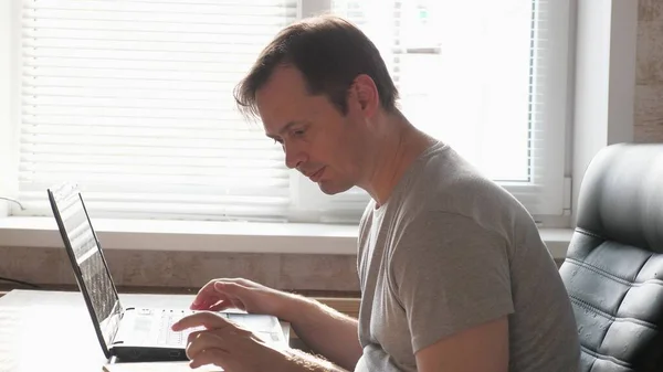 Homme d'affaires concentré, entrepreneur travaillant sur un ordinateur portable à la maison. Jeune homme professionnel utilisant un ordinateur, travaillant à domicile. Travailleur indépendant occupé à travailler avec un ordinateur portable moderne. — Photo