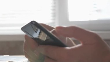 Akıllı telefonun ellerindeydi. Yakın plan. Freelancer modern taşınabilir cihazlar üzerinde çalışmakla meşgul. İş adamı, iş kadını dizüstü bilgisayarla çalışıyor ve evde akıllı telefon var. Ofiste çalışmak için aygıt kullanmak..