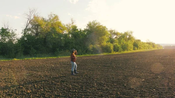 Rolnik sprawdza jakość gleby przed siewem. Bizneswoman sprawdza zaorane pole. Farmerka z tabletkami w terenie. Samica agronomii sprawdza jakość siewu ziarna. — Zdjęcie stockowe