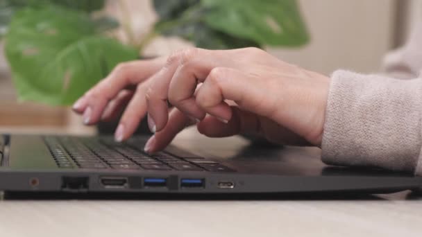 Las manos femeninas de una mujer de negocios que trabaja en la computadora. Estudiante escribiendo texto en el teclado del ordenador portátil. Mujer sentada en el escritorio de la oficina en casa, trabajando en línea. Una mujer en la oficina trabaja en la computadora moderna en línea. — Vídeos de Stock