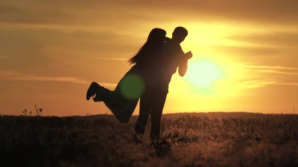 Hombre feliz baila y gira con su amada mujer en un parque de verano. El chico y la chica están bailando en los brillantes rayos del sol en el campo. La familia despreocupada baila al atardecer. Personas libres. — Foto de Stock