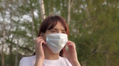 Genç kadın tıbbi maskesini çıkarıyor. Kız kameraya bakarak derin derin nefes alıyor ve gülümsüyor. Sağlık ve tıbbi konsept. Portreyi kapat. Salgın sırasında yaşam. Coronavirus. covid-19