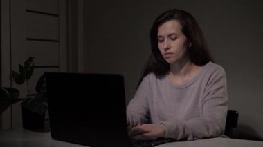 Dizüstü bilgisayarda yazı yazan yorgun bir iş kadını. Bilgisayarda çalışan serbest çalışan bir kadın. Kadın ofis masasında oturuyor, internette çalışıyor. Ofisteki kadın modern bilgisayarda çalışıyor..