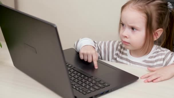 Ребенок учится пользоваться компьютером. Маленький ребенок играет за компьютером на рабочем месте матери. Моя дочь играет с ноутбуком, папа не видит. Счастливый ребенок изучает гаджет в офисе своих родителей. — стоковое видео