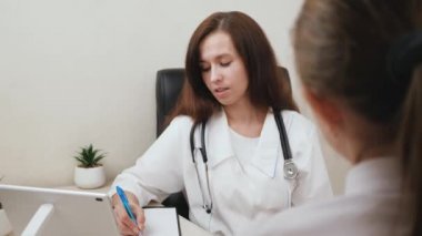 Terapist hasta bir kadınla çalışır. Doktor hastaların şikayetlerini kaydeder. Aile doktoru ofisteki bir hastayla konuşuyor. Beyaz önlüklü ve steteskoplu akıllı kadın doktor hasta hakkında tavsiye veriyor.