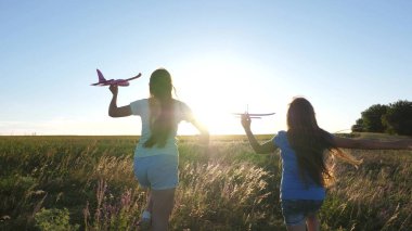 Çiçek tarlasında bir uçakta oynayan çocukların silueti. Uçma hayalleri. Mutlu bir çocukluk. Gün batımında iki kız bir oyuncak uçakla oynuyor. Güneşin arka planındaki çocuklar ellerinde bir uçakla.