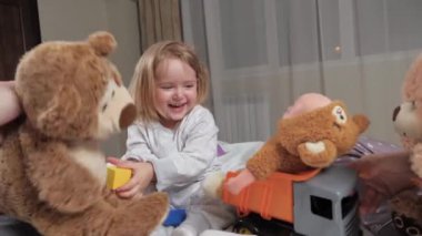 Mutlu çocuk evde en sevdikleri oyuncaklarla anne ve babalarıyla gülüp oynuyor. Pijamalı şirin bir çocuk evde ailesiyle oynamaktan memnun. Aile kaygısız kızlarıyla oynar, mutlu bir çocukluk geçirirler.