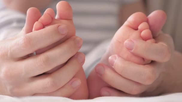 Baby feet in mother s hands. Feet of an infant, mom will embrace the baby with her arms. Happy Mother and her baby are playing together. Happy family concept. Childcare happy childhood. Family moments — 图库视频影像