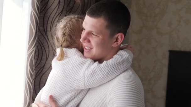 Happy cute affectionate little child girl, hugs her beloved dad and smiles. Adorable little daughter hugging her father at home. Happy family playing together at home. Healthy joyful childhood — Stock Video