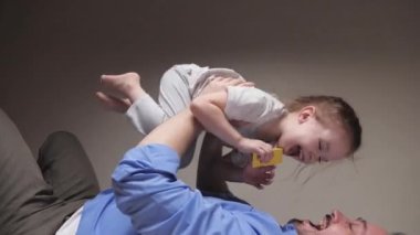 Kaygısız, sevgi dolu bir aile babası. Küçük, tatlı bir çocuk babası. Süper kahraman bir uçak gibi yere yatıp eğleniyor.