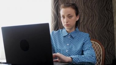 Genç bir kadın, iş adamı, dizüstü bilgisayarda çalışıyor, klavyeye belgeler yazıyor. Ofiste, evde bilgisayarla çalışan profesyonel bir kadın. Modern bir dizüstü bilgisayarla çalışan serbest çalışan biri..