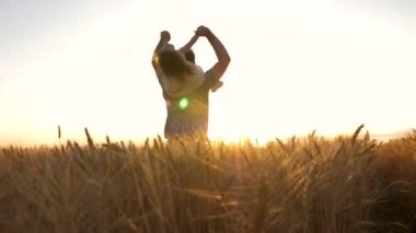 Mutlu çocuk ve baba olgunlaşan buğday tarlasında oynuyorlar. Küçük kız babasının omuzlarında. Bebek ve babası sahada seyahat ediyor. Çocuk ve ebeveyn doğada oynuyorlar. Mutlu aile ve çocukluk kavramı