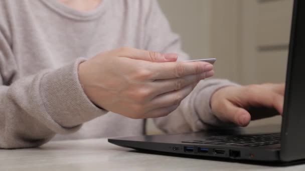 Freiberufler arbeiten von zu Hause aus. Eine Frau sitzt zu Hause an einem Wohnzimmertisch, bedient sich eines Computers, kauft in einem Online-Shop ein, genießt ein Geschäft. Geschäftsfrau arbeitet am Laptop im Internet — Stockvideo
