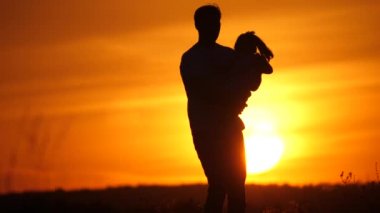 Babam sevgili kızının etrafında güneşleniyor. Mutlu aile, baba ve kızı gün batımında sahada oynayacaklar. Baba ve küçük kızı birlikte eğleniyorlar. Mutlu aile ve sağlıklı çocukluk