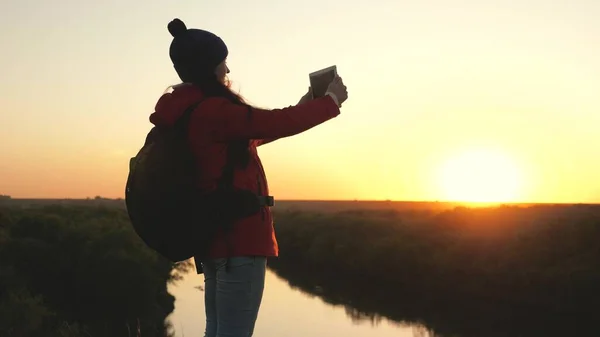 Молодая женщина туристический блогер записывает селфи видео вершины горы с помощью планшетного компьютера на фоне красивого ландшафта. Беззаботная веселая девушка путешествует и фотографирует природу — стоковое фото
