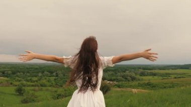 Genç özgür kadın dağın tepesinde duruyor güzel gökyüzünün tadını çıkarıyor, yaklaşan fırtınanın. Kız meditasyon yapıyor ve dua ediyor, iç dünyasını doğada keşfediyor, uzaklığa bakıyor ve elleriyle rüzgarı yakalıyor.