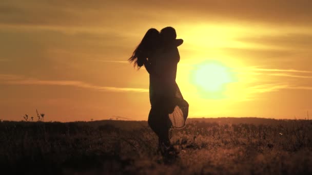 快乐的男人和他心爱的女人在夏天的公园里跳舞和旋转。这男的和女的在田野里的阳光下跳舞。日落时，无忧无虑的家人跳舞。自由的人民. — 图库视频影像