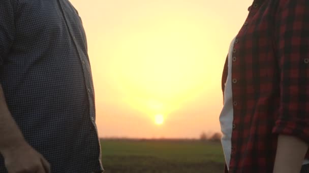 Farmers férfi, nő dolgozik terepen egy táblagéppel. Üzletemberek kezet ráznak a napon, csapatmunka. Az üzletemberek egyetértettek. Üzletemberek alkut kötöttek.. — Stock videók