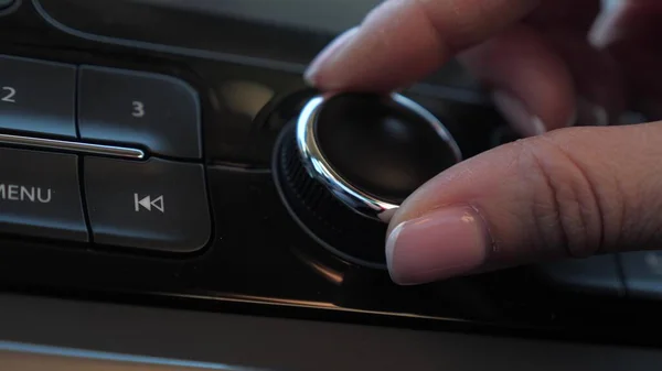 Yolcu, arabadaki en sevdikleri radyo istasyonunu arıyor. Yakın plan. Erkek el araba radyosunu ayarlar. Şoför sesi açıyor. Müzik dinlemek ve arabanla seyahat etmek.