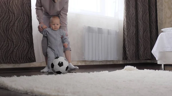 Matka i dziecko, syn grają w futbol w pokoju, kopią piłkę. Dziecko, dziecko, bawi się z matką w domu. Szczęśliwa, zdrowa, wysportowana rodzina. Rozwijaj swoje dziecko poprzez aktywne gry sportowe — Zdjęcie stockowe