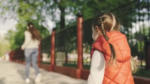 Szczęśliwa rodzina, dziecko, córka i mama biegają wiosną po parku na ulicy. Koncepcja beztroskiego dzieciństwa, radosnego biegania dziecka za matką. Małe dziecko bawi się bawiąc się latem na placu zabaw. — Wideo stockowe