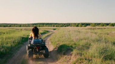 Kız Dörtlü bisiklet, macera, seyahat, turizm kullanıyor. Özgür bir kadın yazın toprak bir yolda parkta dörtlü bisiklete biniyor. Off-road ATV macerası. İlkbaharda açık hava aktiviteleri, açık hava seyahatleri