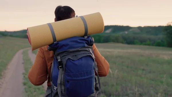 Viaggiatore viaggia strada di campagna, ecoturismo, escursioni, incredibile, sconosciuto, scoperta. Uomo caucasico sano attivo con zaino cammina foresta. Uomo viaggiatore, escursioni in estate, stile di vita sano. — Foto Stock