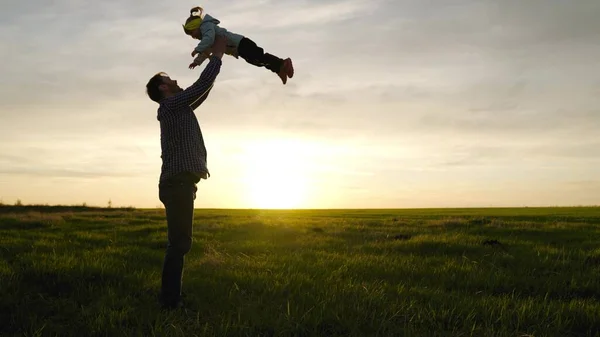 아버지는 행복 한 딸을 햇살을 받아 푸른 하늘로 던져 넣는다. 아버지와 어린 아이가 함께 놀고, 웃고 안 아 줍니다. 행복 한 가족 여행. 부모의 품에 안긴 아기. 아빠쉬는 날이야. 행복 한 가족에 대한 개념 — 스톡 사진