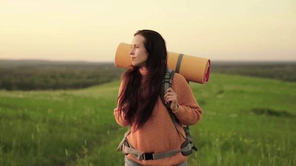 Ragazza viaggiatore viaggia su erba verde e fiori, meditazione, ecoturismo, escursioni. Viaggiatore donna libera a piedi attraverso il prato in estate. Una giovane donna caucasica attiva con lo zaino va in escursione. — Foto Stock