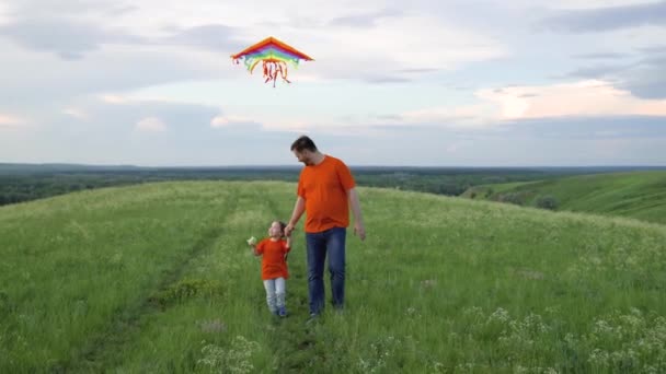Happy family, daughter and dad raise a kite into the sky. Family weekend play outdoors. Child and dad play together with kites against the sky in the park. The concept of healthy children and parents. — Stock videók